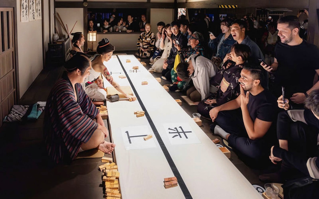 Tourists enjoying a traditional game at TOEI Kyoto Studio Park.