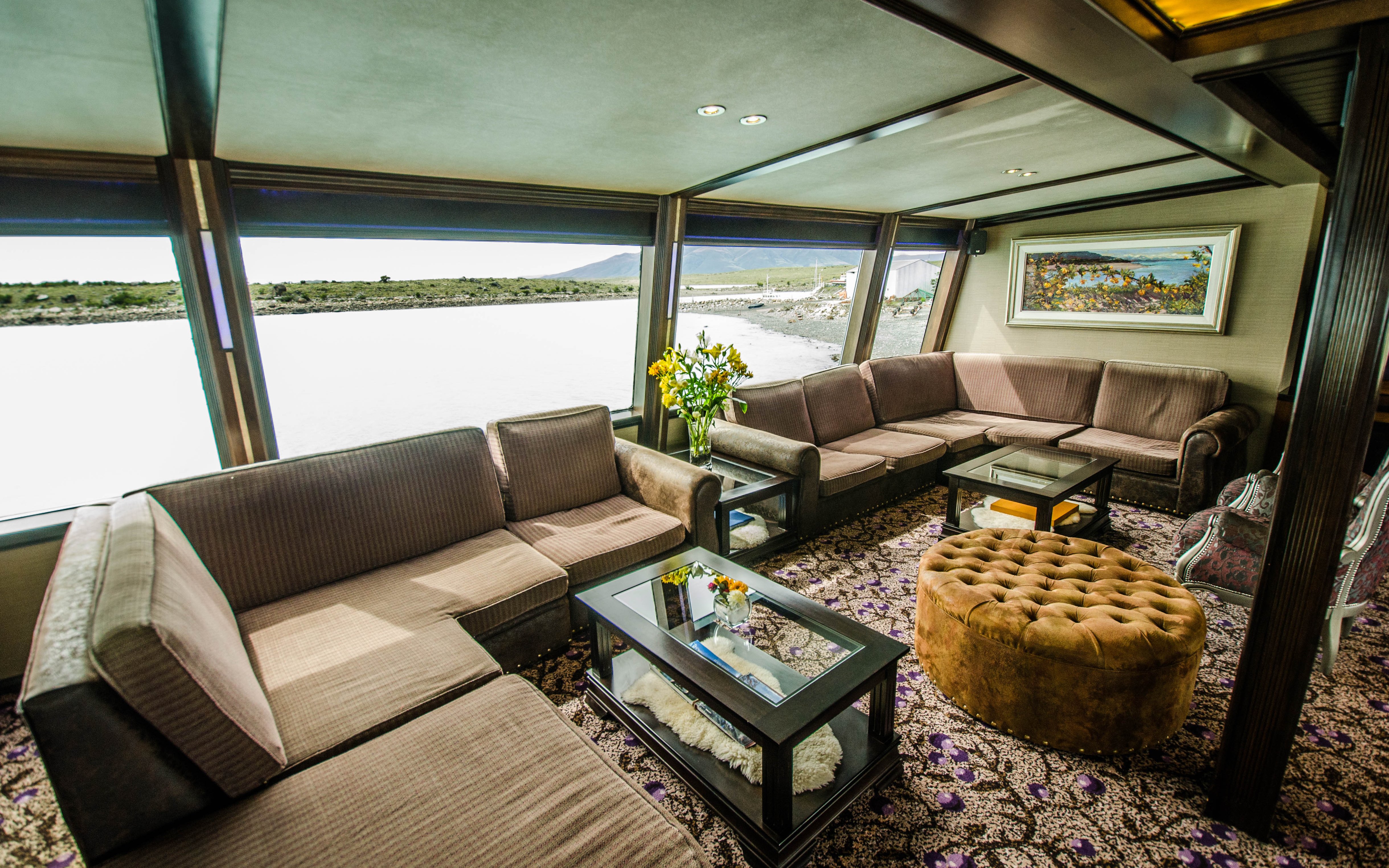 Interior of a boat lounge with large windows during Spirit of the Glaciers tour.