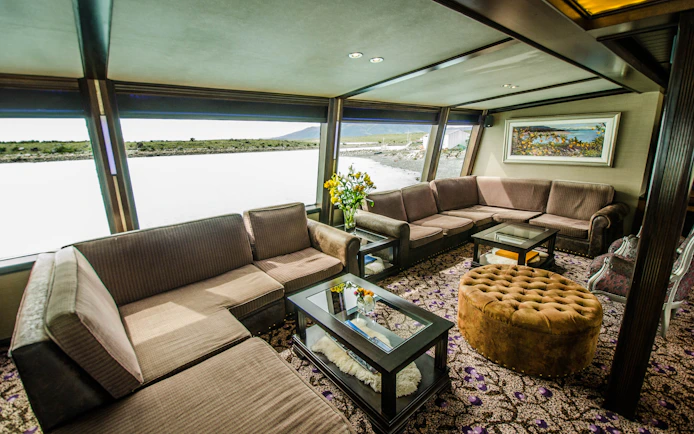 Interior of a boat lounge with large windows during Spirit of the Glaciers tour.