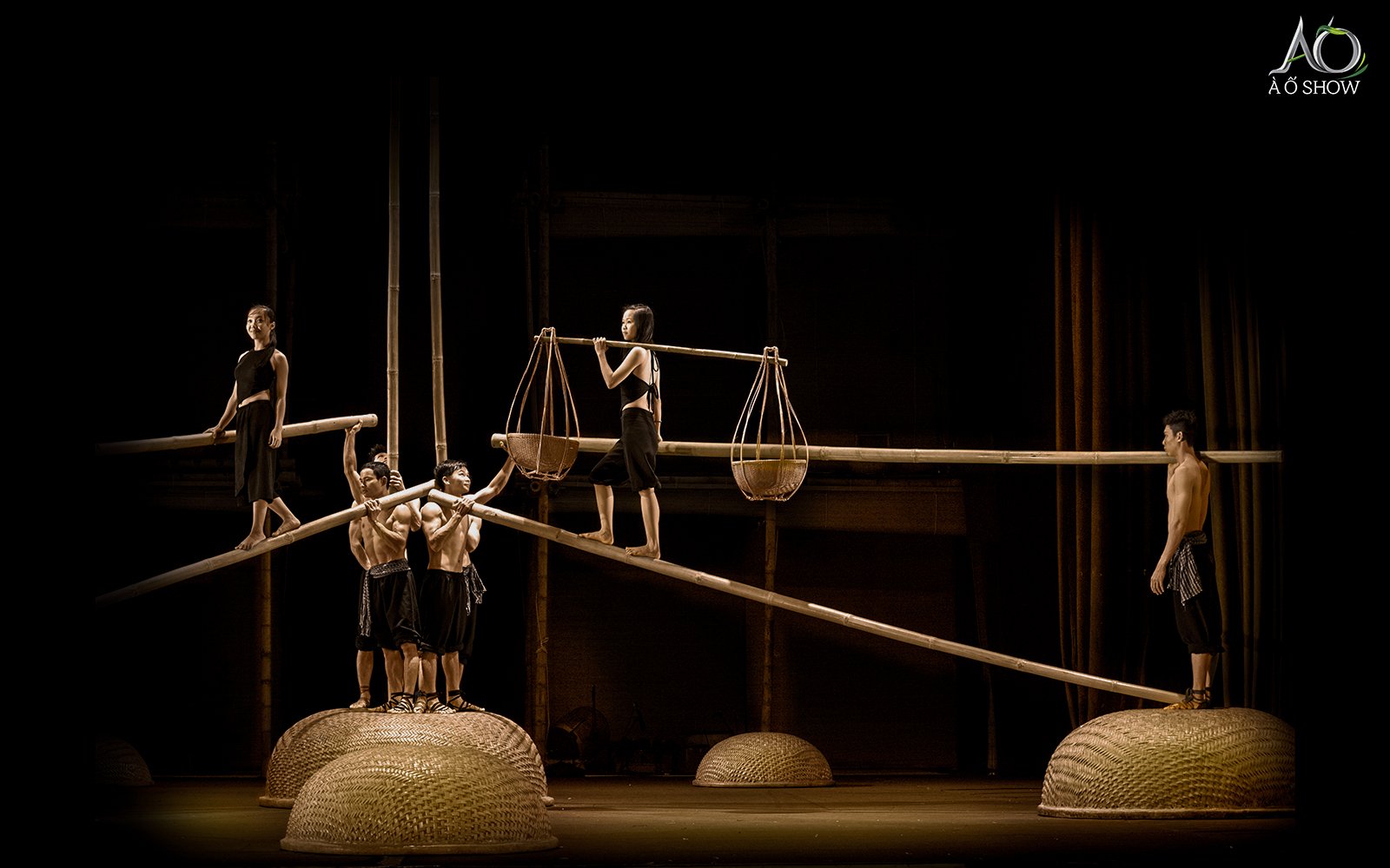 Performers balancing on bamboo poles during AO show traditional act.