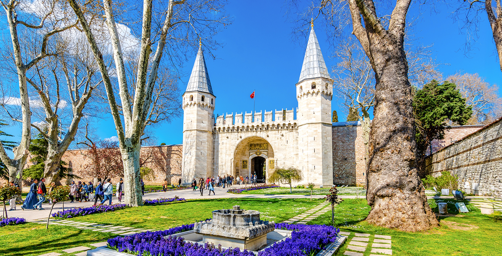 Gate of Salutation entrance at Topkapi Palace, Istanbul, with tourists exploring the historic site.
