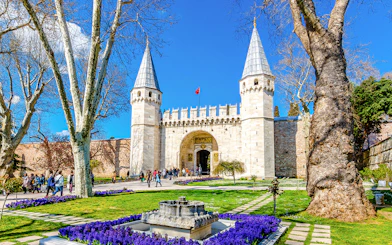Gate of Salutation entrance at Topkapi Palace, Istanbul, with tourists exploring the historic site.