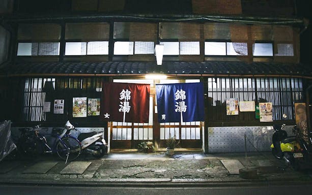 Traditional Kyoto bathhouse entrance with lanterns and bicycles.