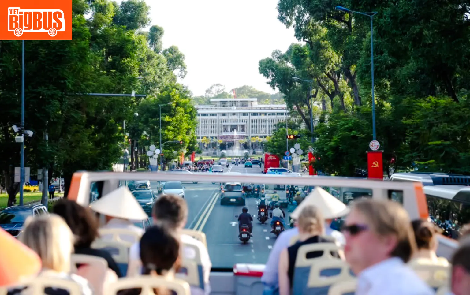 Open-top bus tour approaching Independence Palace, Ho Chi Minh City.