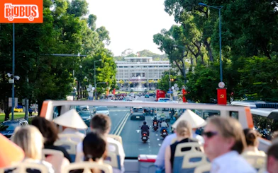 Open-top bus tour approaching Independence Palace, Ho Chi Minh City.