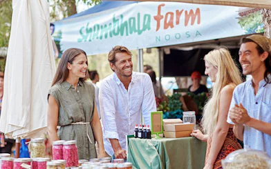 Visitors enjoying local produce at Eumundi Markets stall in Noosa.