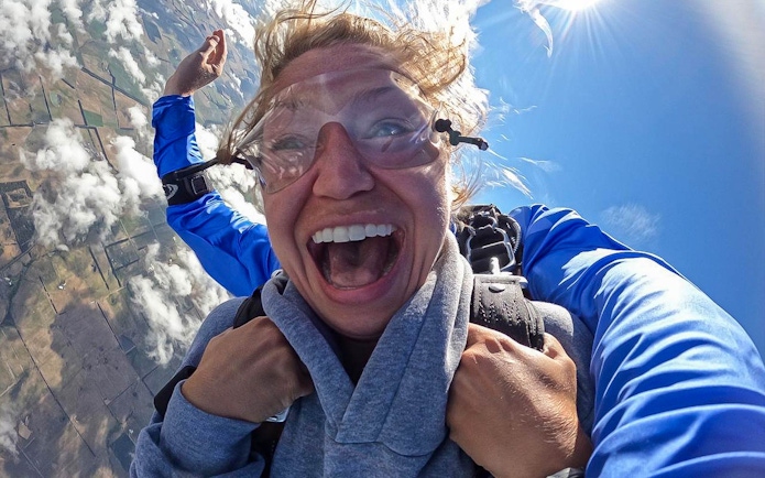 Participant exhilarated during tandem skydive near the 12 Apostles, Australia.