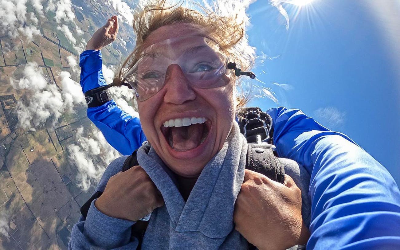 Participant exhilarated during tandem skydive near the 12 Apostles, Australia.