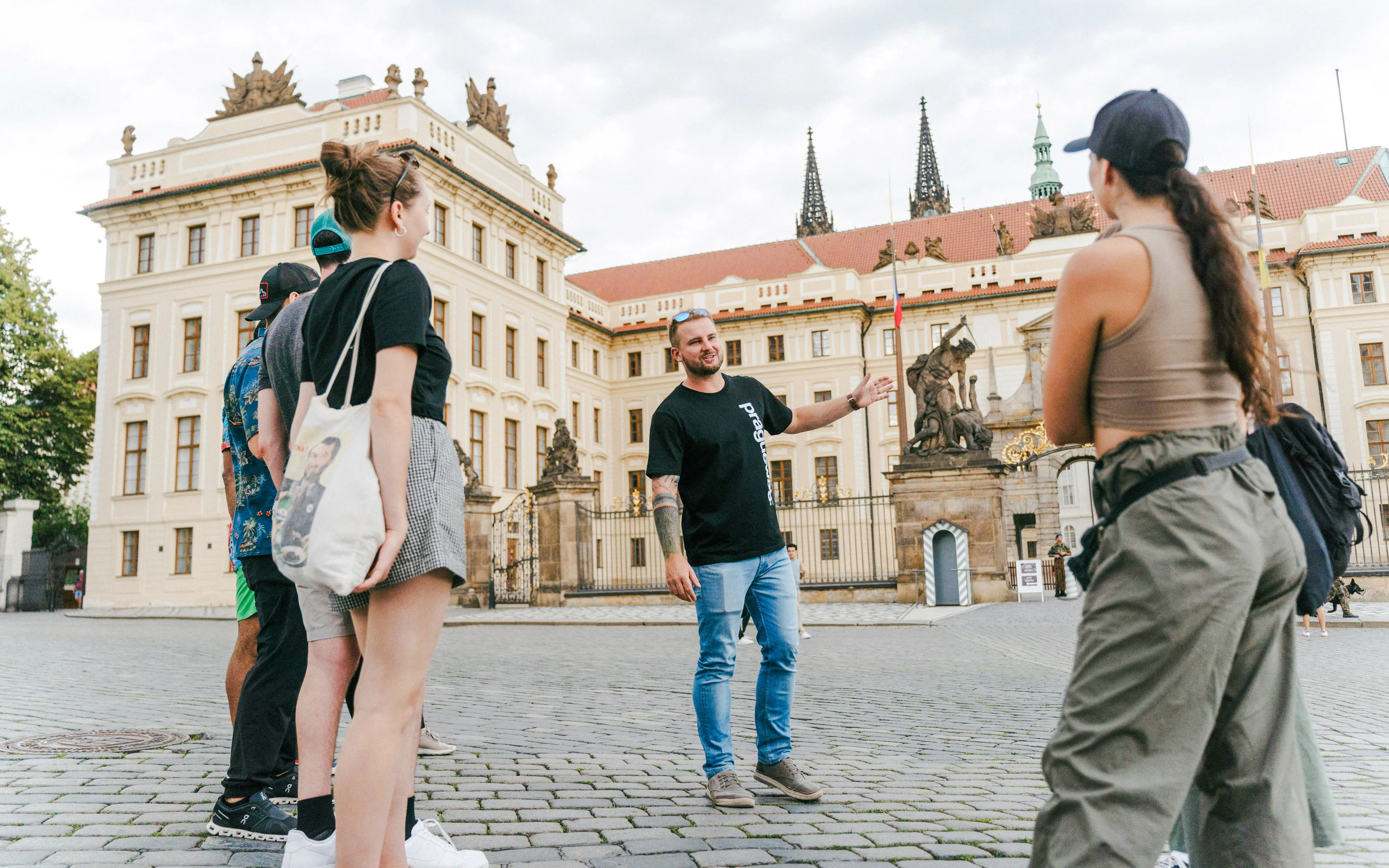 Guests touring near Prague Castle with a guide explaining the architecture.