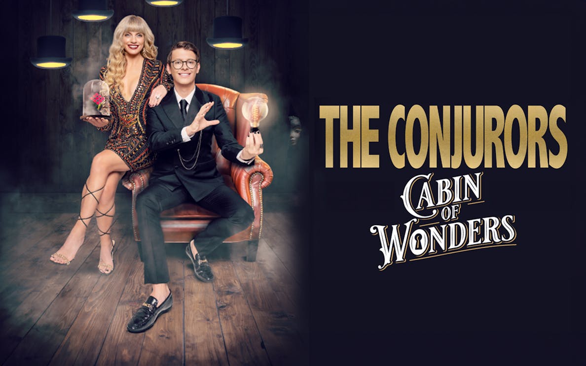 The Conjurors performing magic in a dimly lit room with vintage decor.