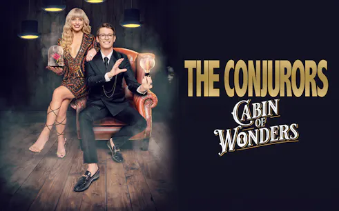 The Conjurors performing magic in a dimly lit room with vintage decor.