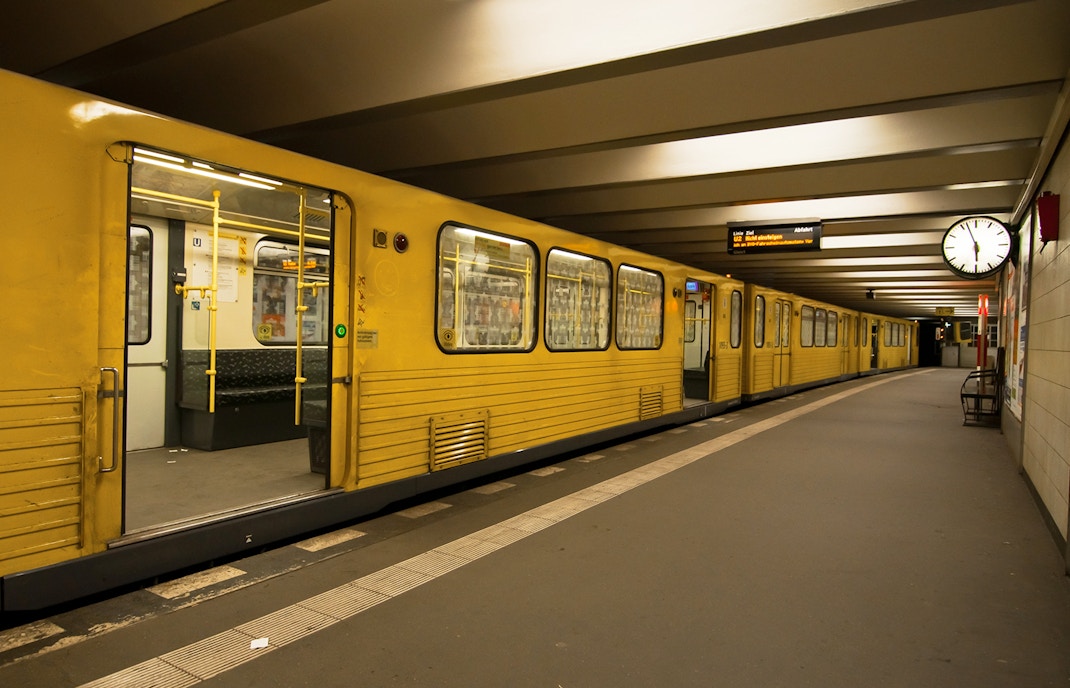 Gelbe Berliner U-Bahn mit geöffneten Türen am Bahnsteig