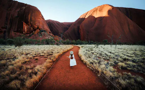 Tourist walking along a path in Uluru-Kata Tjuṯa National Park, Australia.