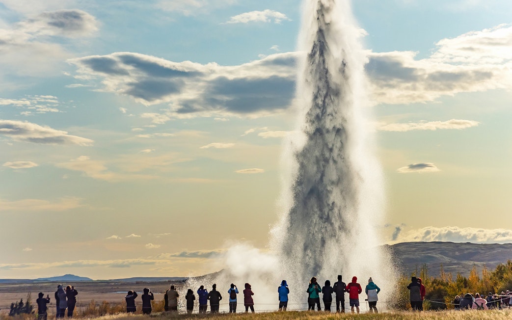Tourists watching Strokkur geyser erupt in Iceland's Golden Circle.