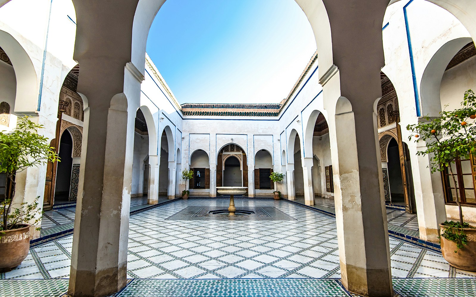 Bahia Palace courtyard with arches and fountain in Marrakech, Morocco.