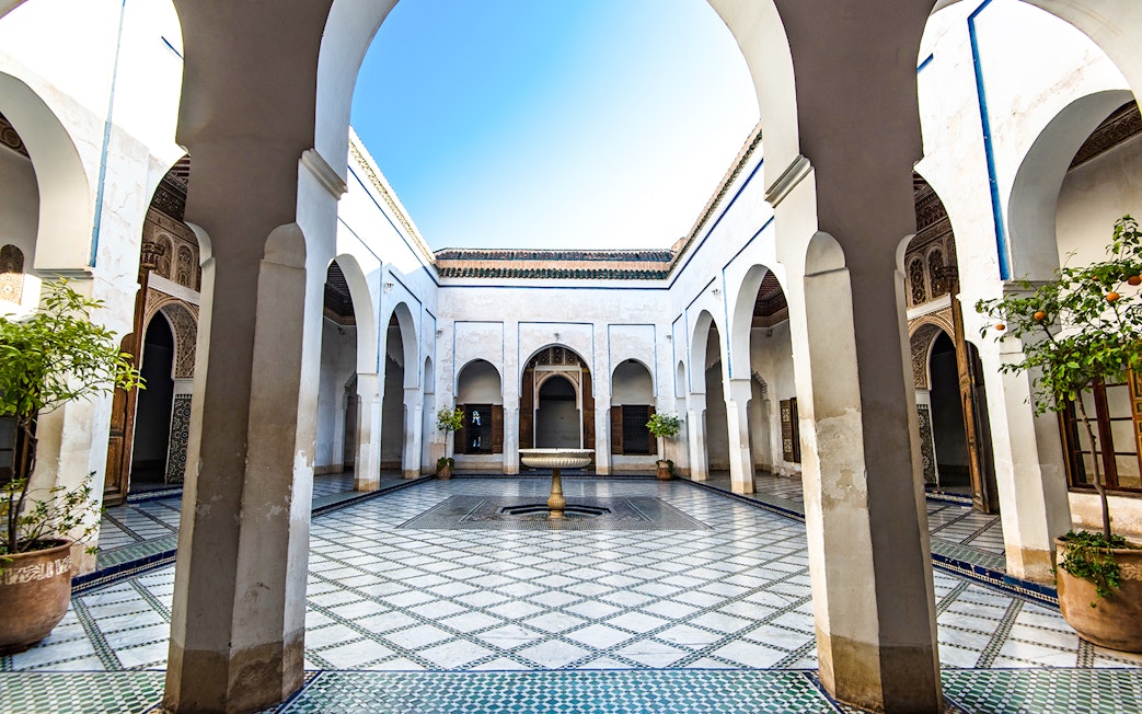 Bahia Palace courtyard with arches and fountain in Marrakech, Morocco.