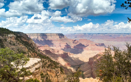 Grand Canyon view with layered rock formations under a cloudy sky, part of Hummer tour experience.