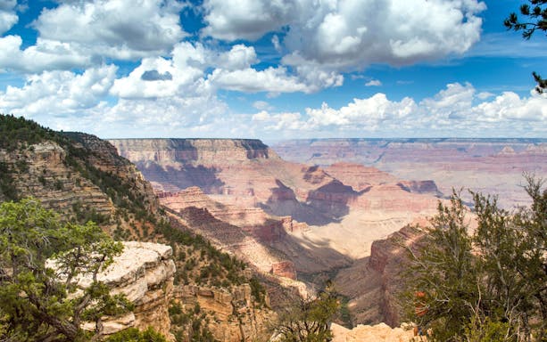 Grand Canyon view with layered rock formations under a cloudy sky, part of Hummer tour experience.