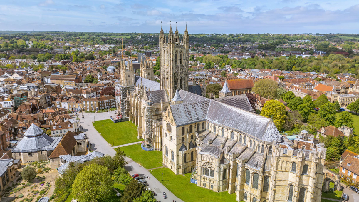Aerial view of Canterbury Cathedral, historic site in Canterbury, England, surrounded by cityscape and greenery.