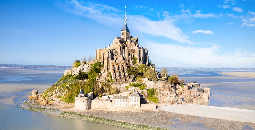 Mont-Saint-Michel abbey on rocky island surrounded by tidal waters in Normandy, France.