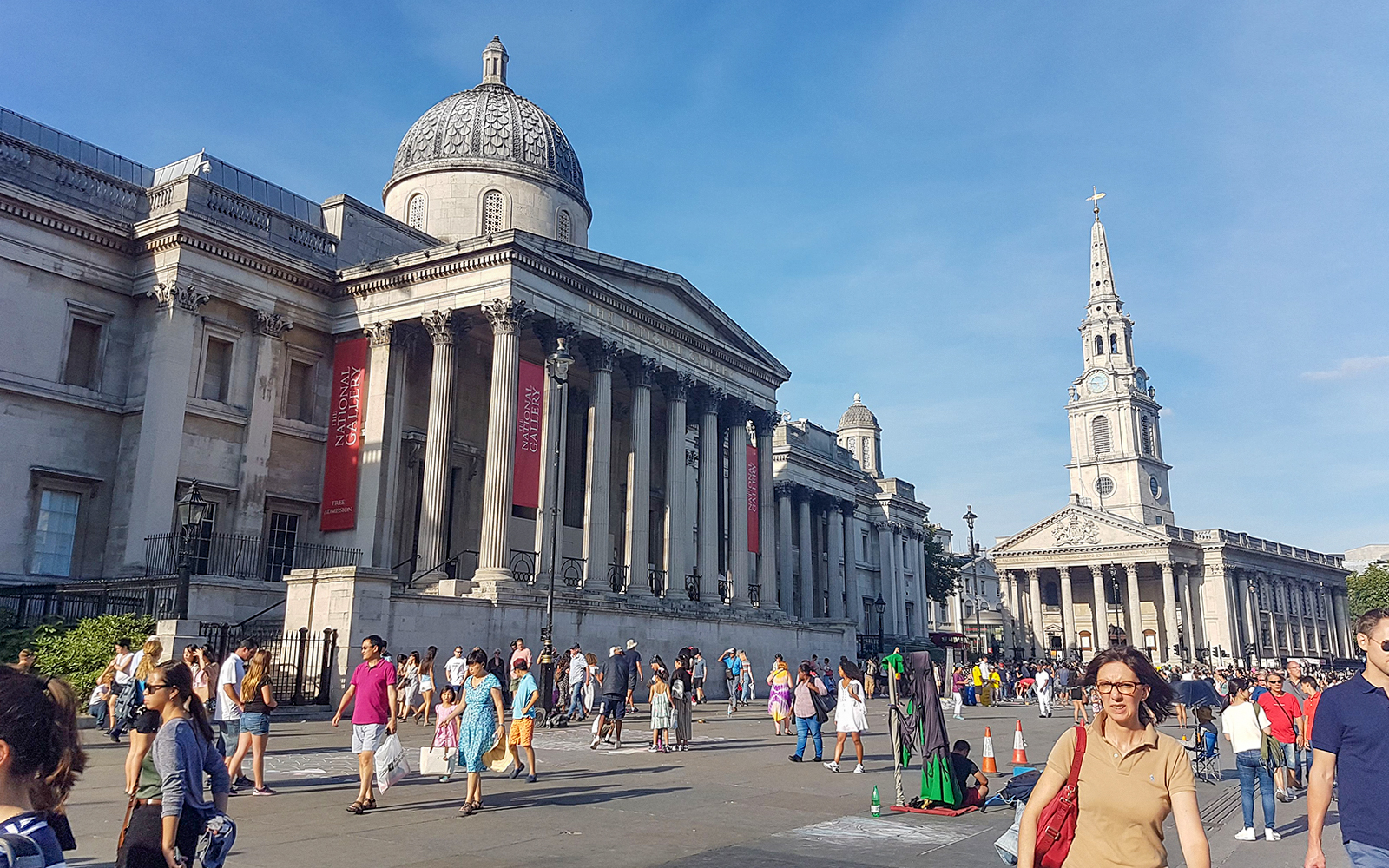 National Gallery and St Martin-in-the-Fields church in London with tourists exploring the area.