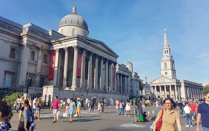 National Gallery and St Martin-in-the-Fields church in London with tourists exploring the area.