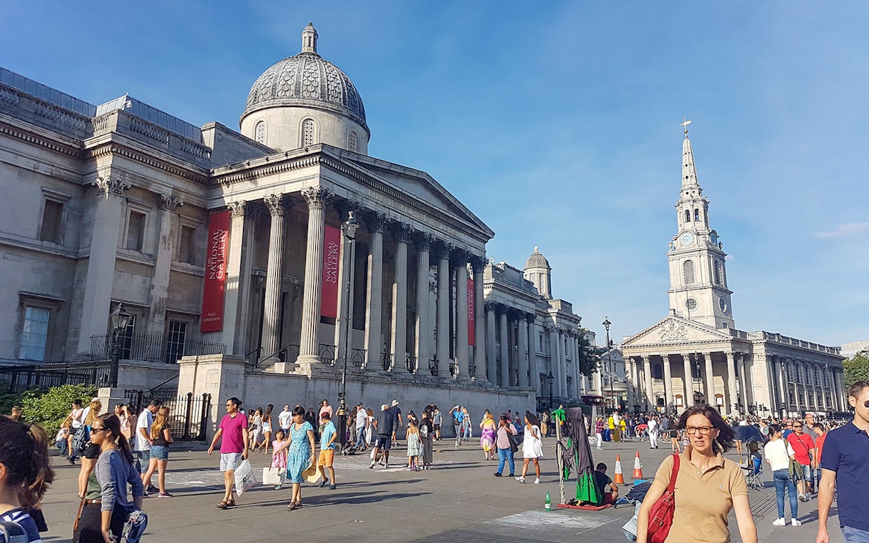 National Gallery and St Martin-in-the-Fields church in London with tourists exploring the area.
