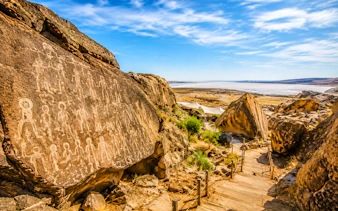 Petroglyphs on rocks at Gobustan National Park, Baku, with a view of the Caspian Sea.