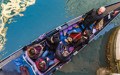 Gondola ride in Venice with musician playing accordion and passengers enjoying the serenade.