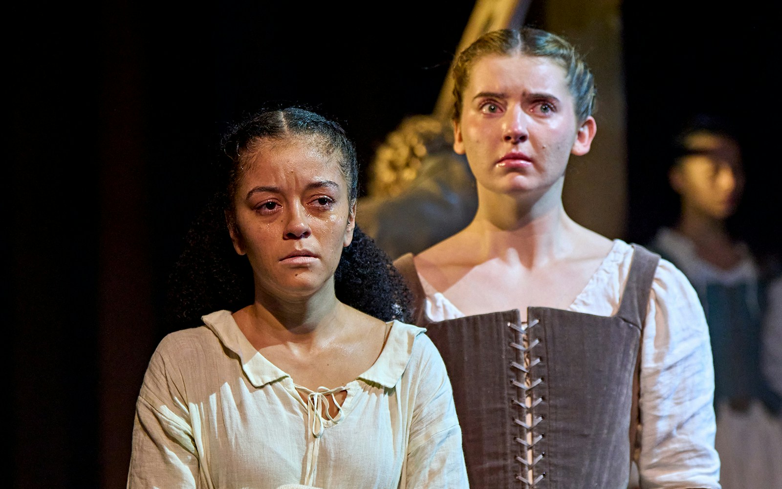 Actors performing a scene from the play "Hamnet" on stage.