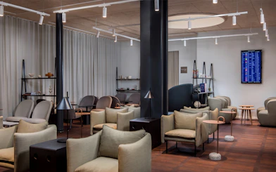 Aspire Lounge seating area with modern chairs and tables at Copenhagen Kastrup Airport Terminal 2.
