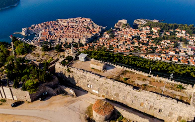 Aerial view of Dubrovnik's Old Town and fortifications, highlighting historical architecture.