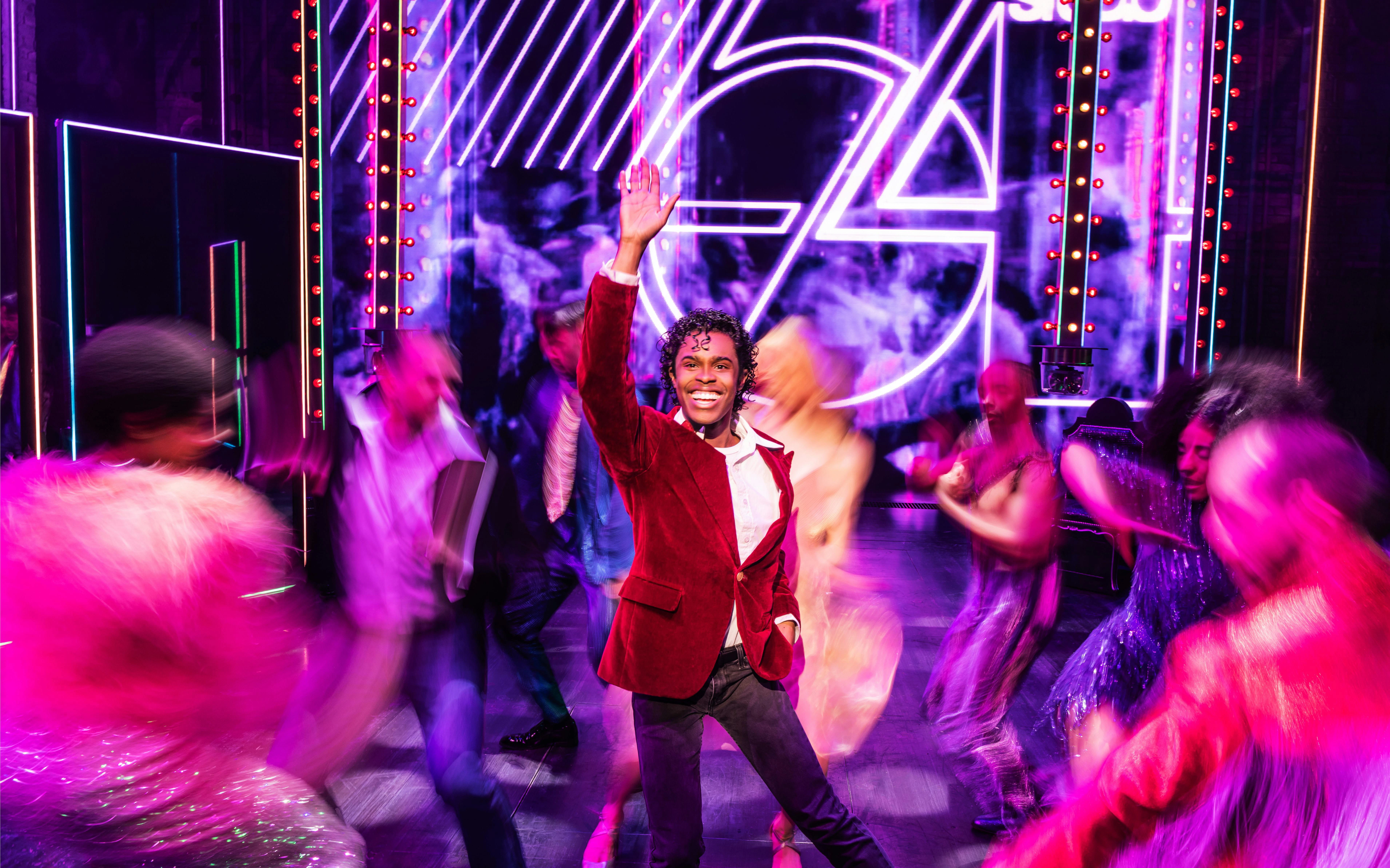 Performer on stage during MJ the Musical on Broadway, surrounded by dancers.