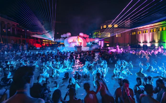 Crowd enjoying Sparty event with DJ and lights at Széchenyi Thermal Bath, Budapest.