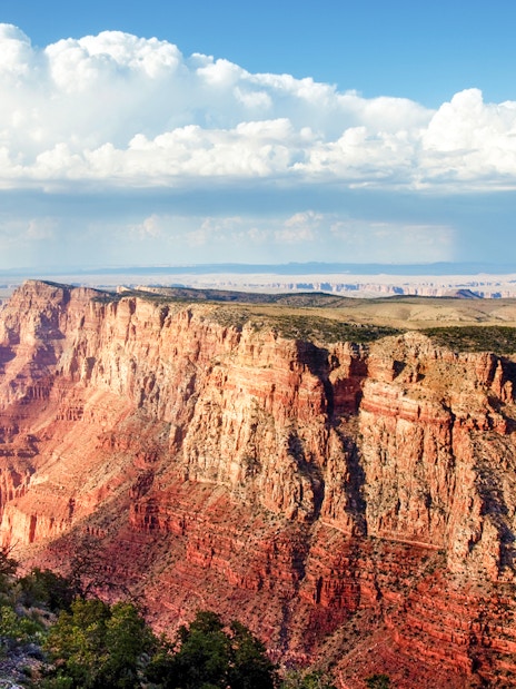 Grand Canyon view with layered red rock formations under a cloudy sky.