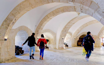 Visitors exploring the stone arches and cannons inside Belem Tower, Lisbon.