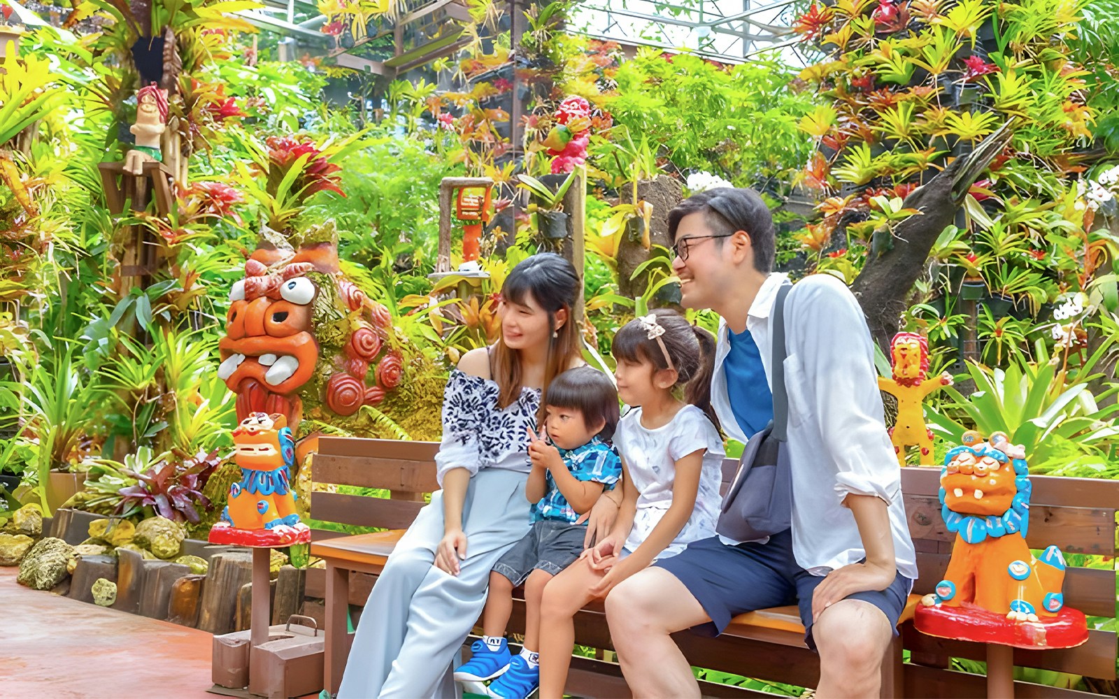 Family enjoying colorful garden at Nago Pineapple Park, Okinawa.