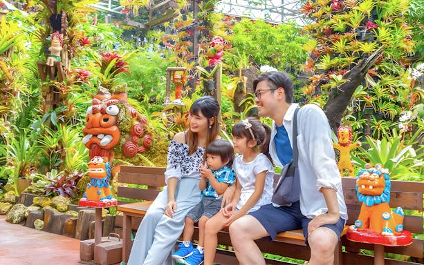 Family enjoying colorful garden at Nago Pineapple Park, Okinawa.