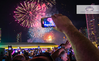 Fireworks over Chao Phraya River during New Year's Eve dinner cruise, Bangkok.