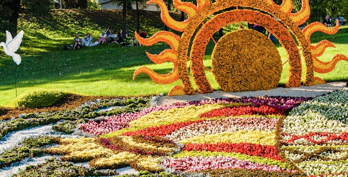 Floral sun sculpture and colorful flower beds at Mainau Flower Island.