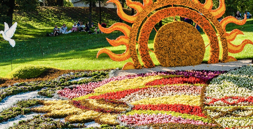 Floral sun sculpture and colorful flower beds at Mainau Flower Island.