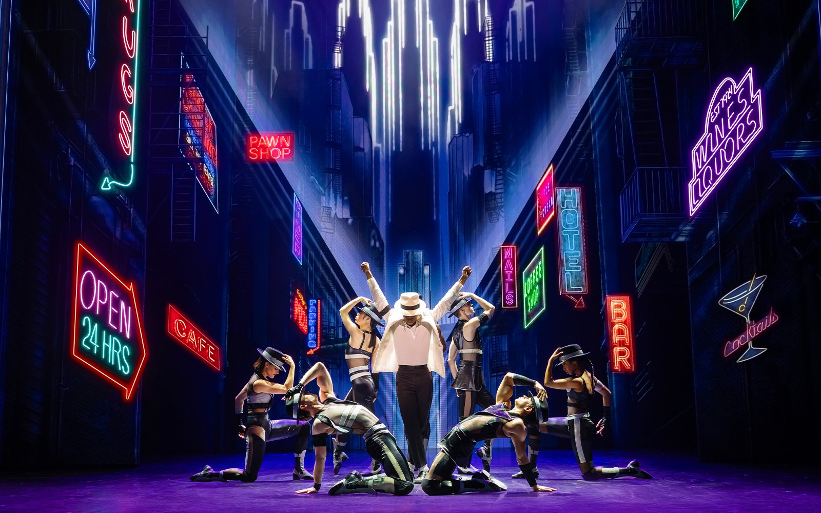 Stage performance of MJ the Musical in Brisbane with dancers in a neon-lit cityscape.