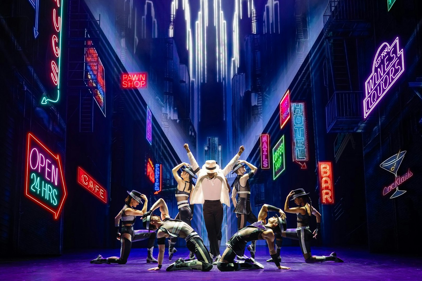 Stage performance of MJ the Musical in Brisbane with dancers in a neon-lit cityscape.