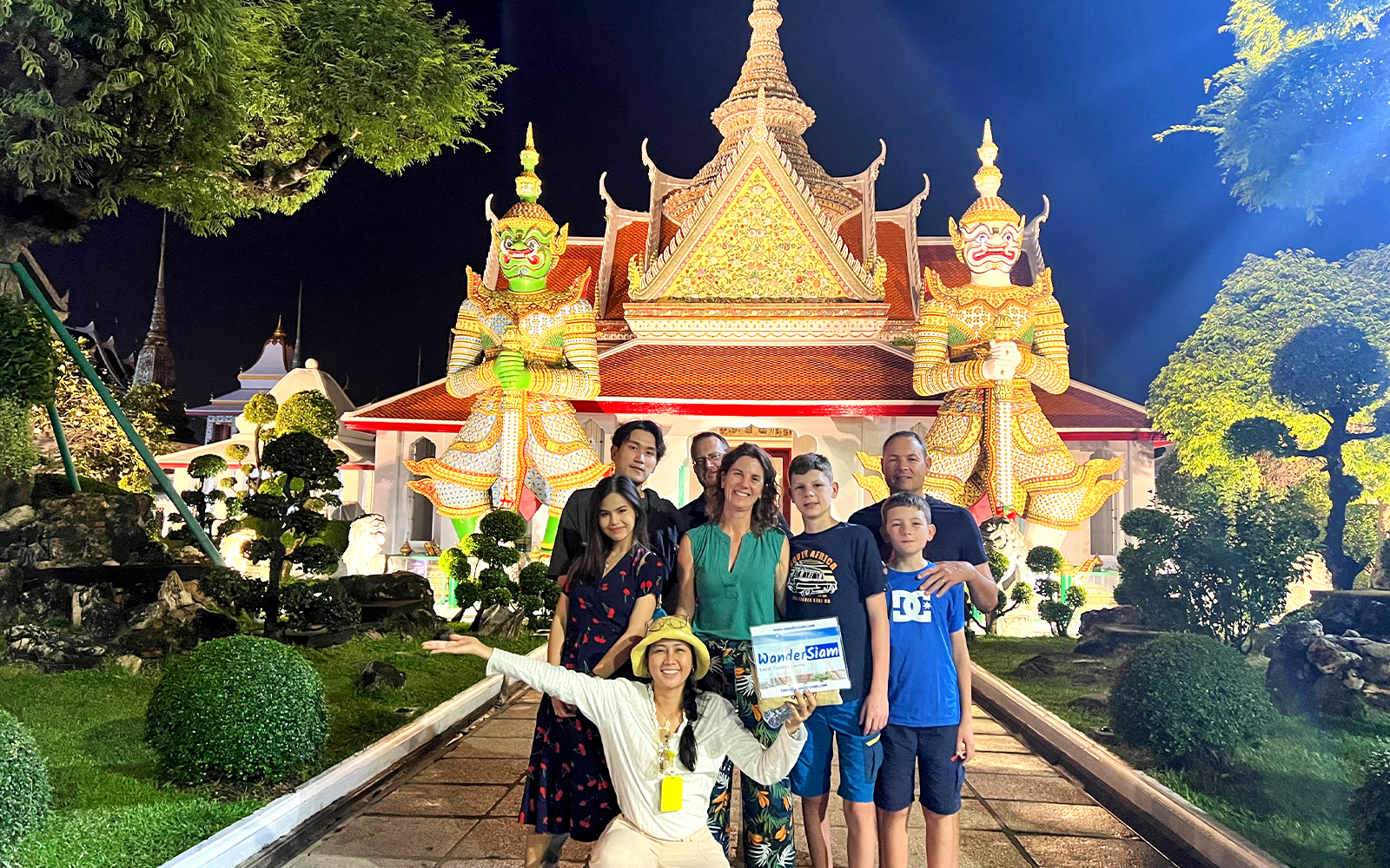 Group in front of Wat Arun temple at night during Bangkok Tuk Tuk tour.
