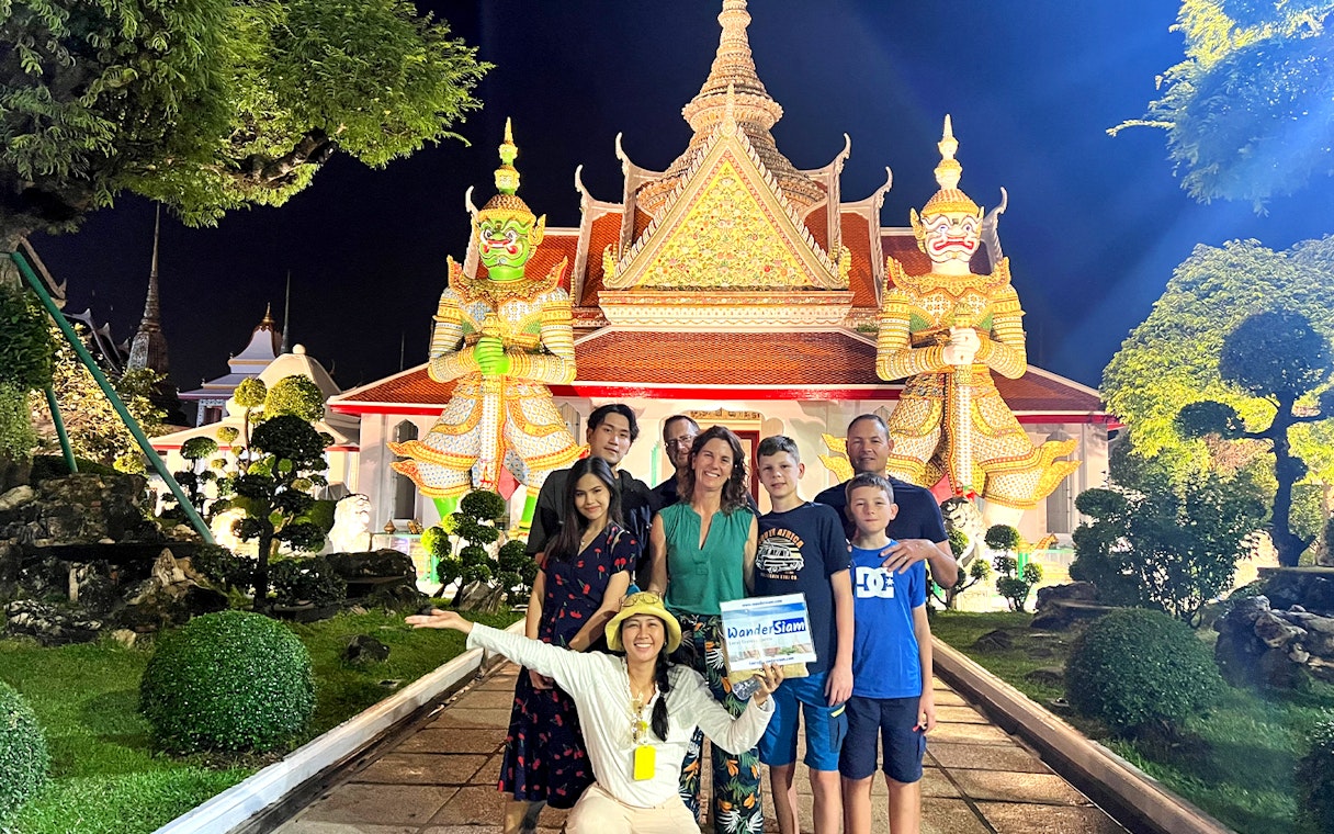 Group in front of Wat Arun temple at night during Bangkok Tuk Tuk tour.