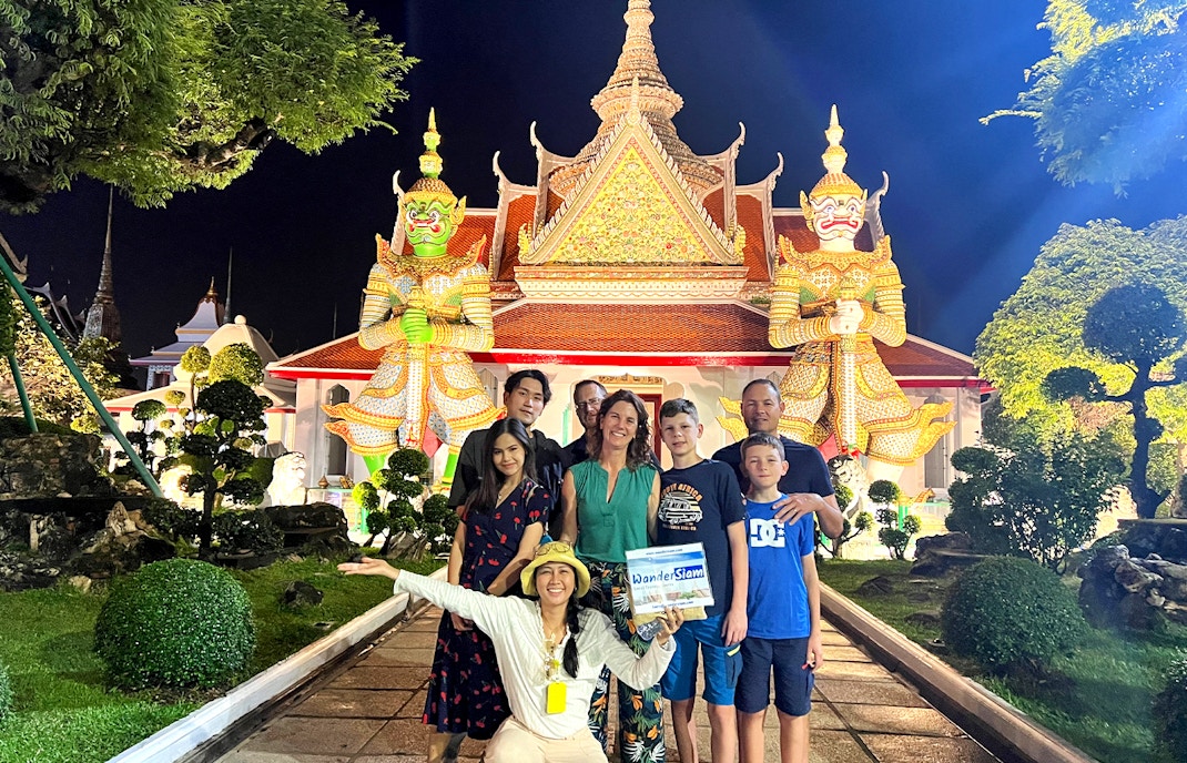 Group in front of Wat Arun temple at night during Bangkok Tuk Tuk tour.
