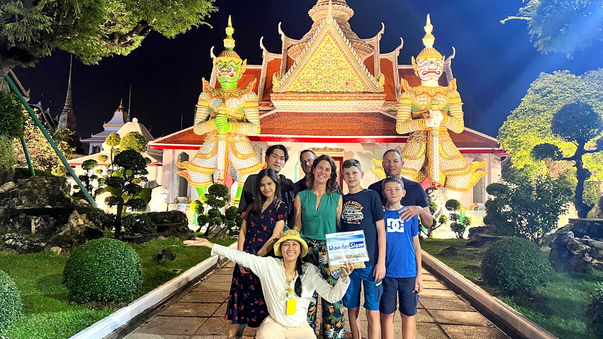 Group in front of Wat Arun temple at night during Bangkok Tuk Tuk tour.