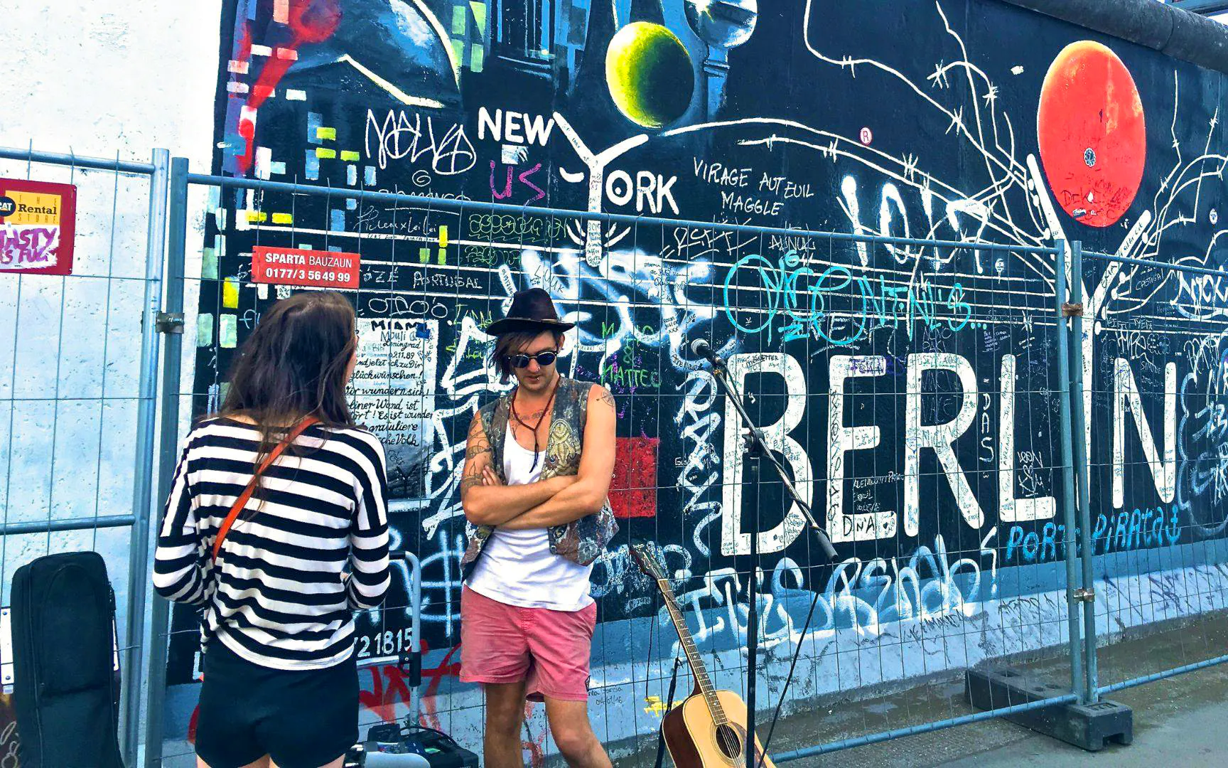 Graffiti-covered Berlin Wall with people and guitar, Berlin Private Walking Tour.