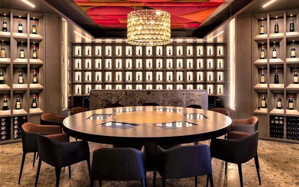 Wine tasting room at Museum of Brunello di Montalcino with bottles displayed on shelves.