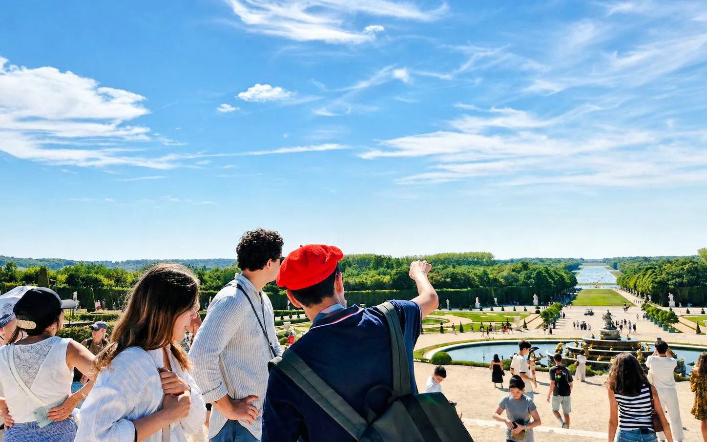 Visitors exploring Versailles Palace gardens on a guided tour, France.